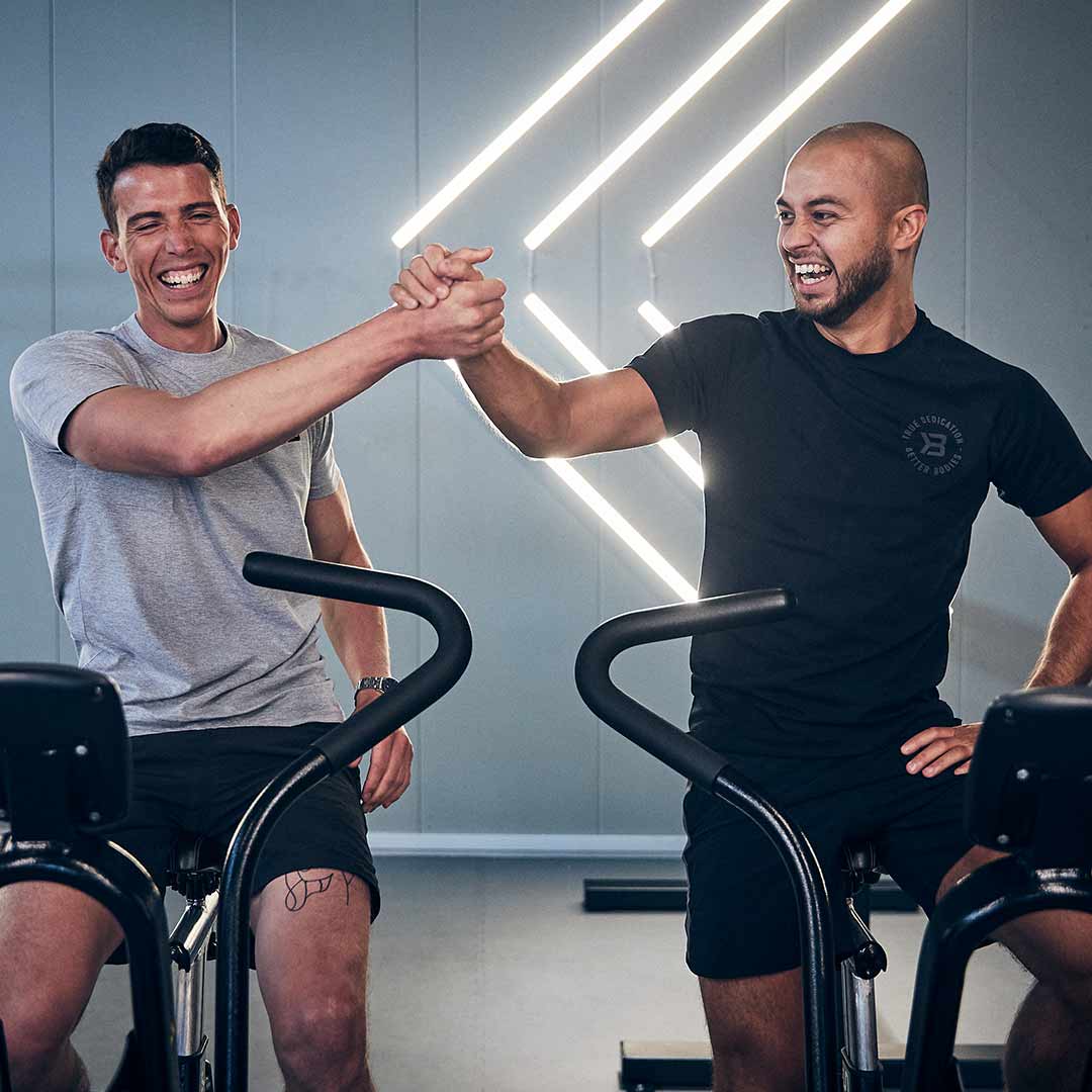 To glade medlemmer tar en high five på treningssenteret