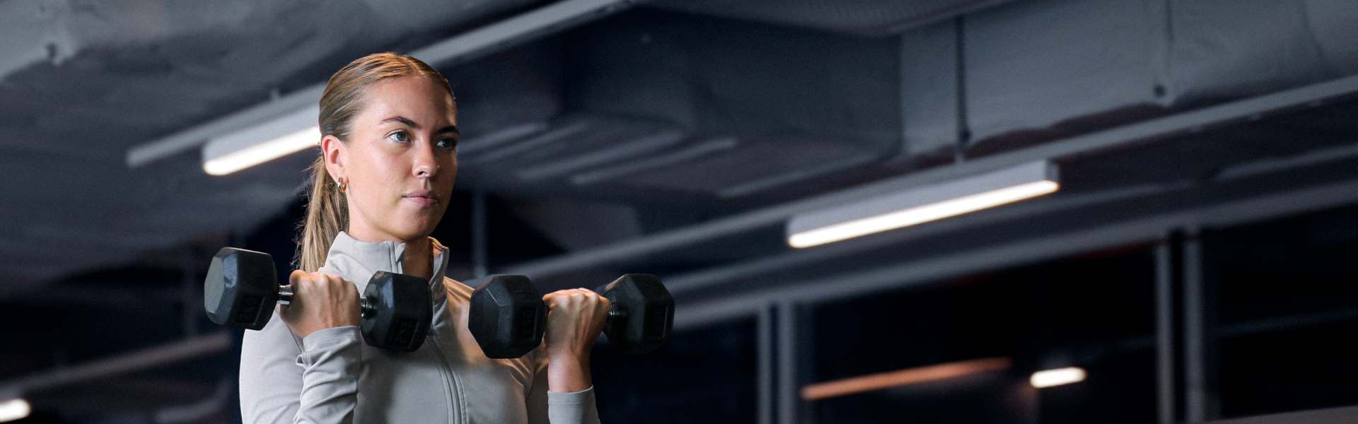Fokusert medlem som trener armer på gymmet